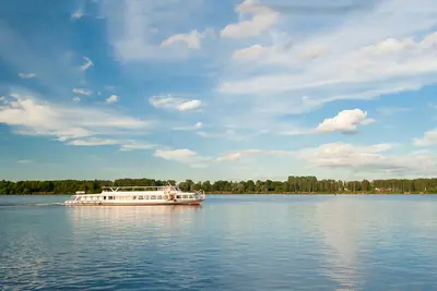 A tourist boat sailing down the river Rhine on a clear summer day.
